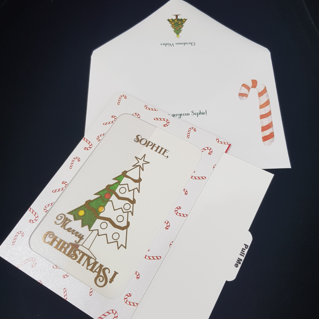 Slider Christmas greeting card. Merry Christmas text. Envelope with red and white candy cane and Christmas tree.