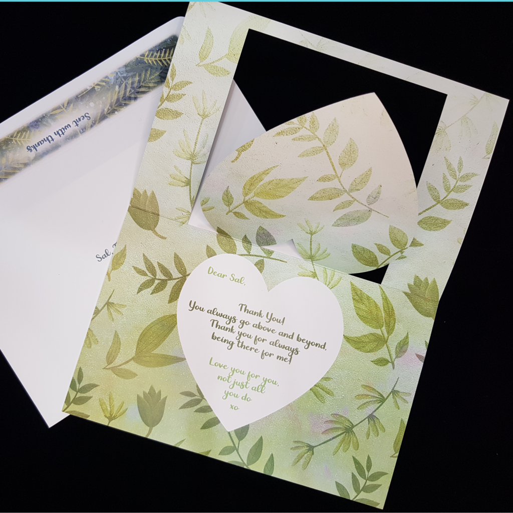 An open card lays on a matching envelope. The entire inside of the card background consists of green foliage. A white heart slightly smaller that the cutout heart sits centrally overlaid on green foliage. A thank you message is written in a light green with the verse in a darker green. Fully customisable