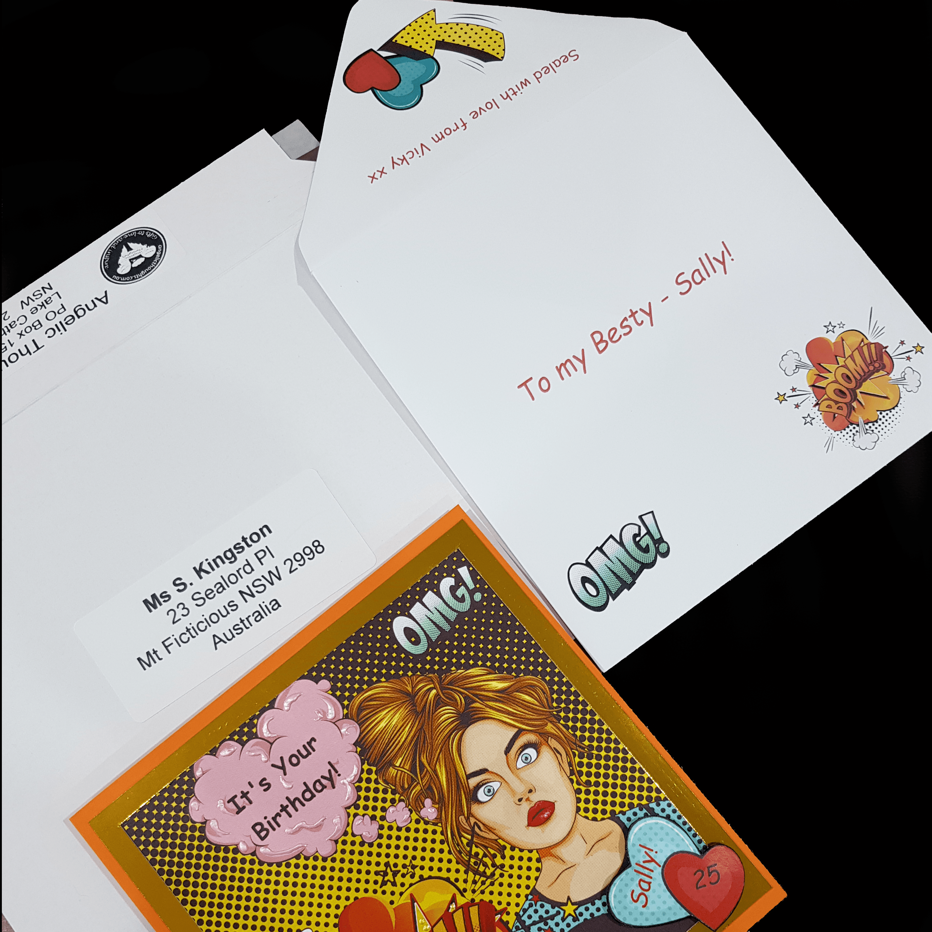 Front of customised card, and open envelope lying on addressed rigid mailer