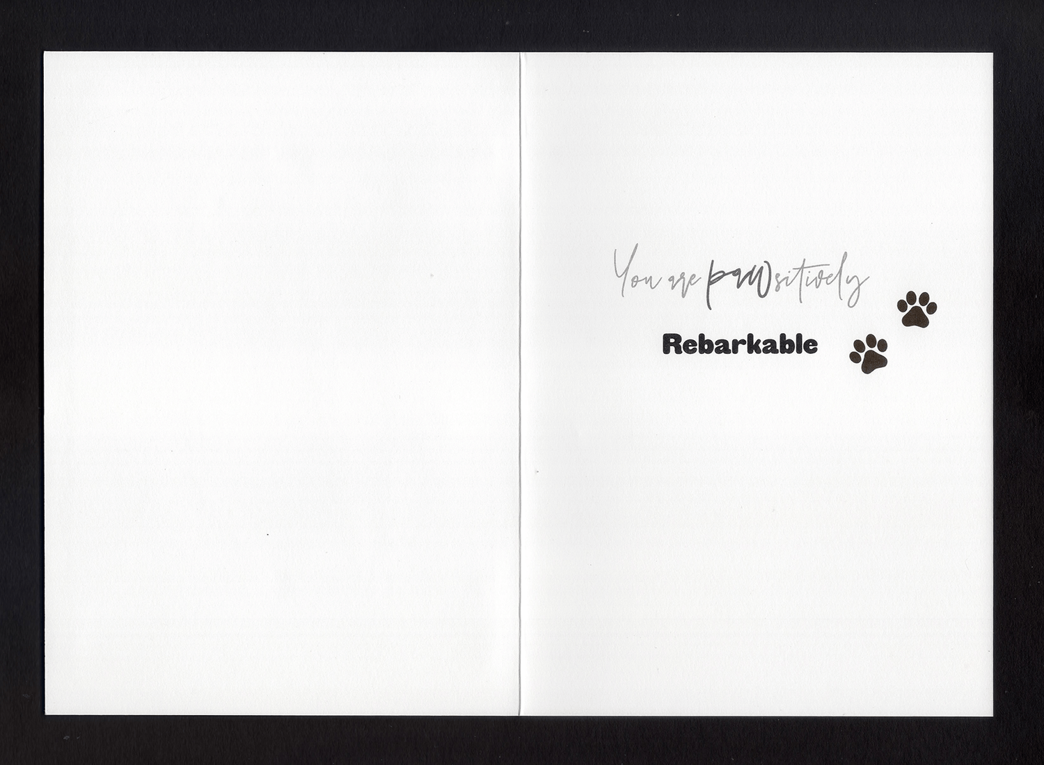 An open card with the words "You are pawsitively rebarkable" and two paw prints