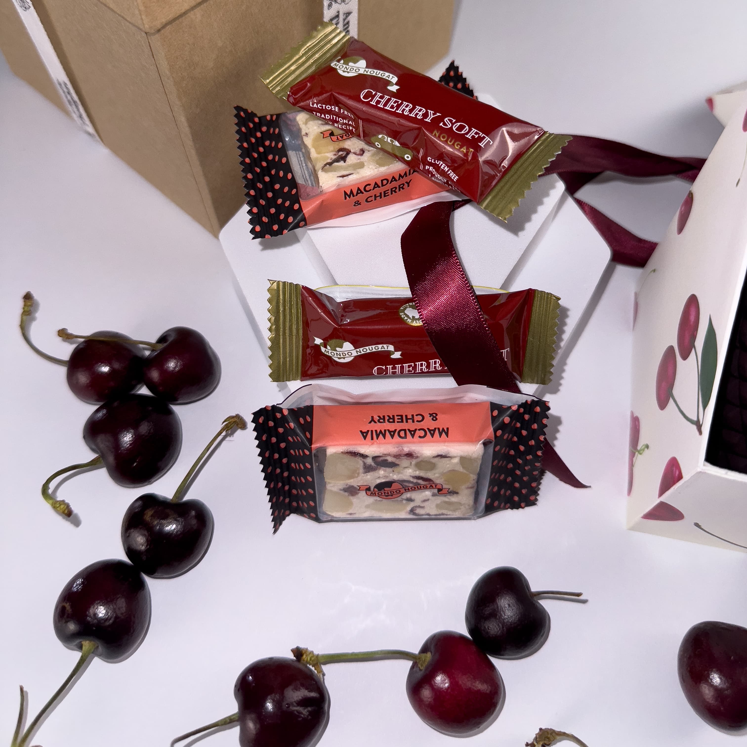 loose cherries scattered amongst 2 x Cherry Soft Nougat, 2 x Cherry &amp; Macadamia Nougat, 
