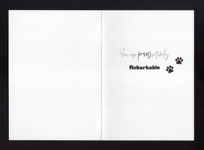 An open card with the words &quot;You are pawsitively rebarkable&quot; and two paw prints 