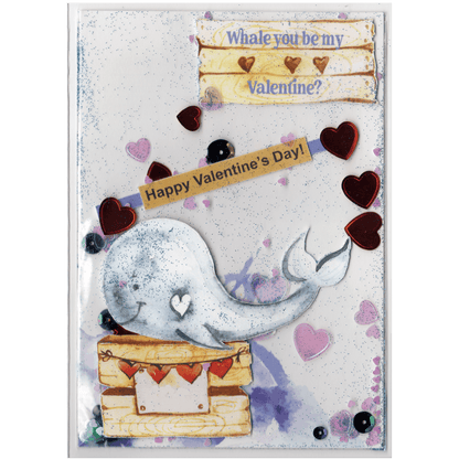 Handmade card featuring a raised cutout whale on a wooden box with heart banner and the customisable name of the recipient. It is fully enclosed in a shaker pocket with irridescent and red hearts of varying sizes and blue glitter.